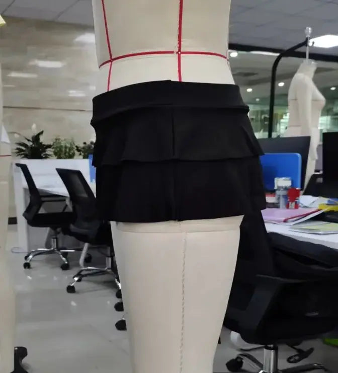 Mini skirt with low waist, black solid color, tiered ruffle hem on a mannequin