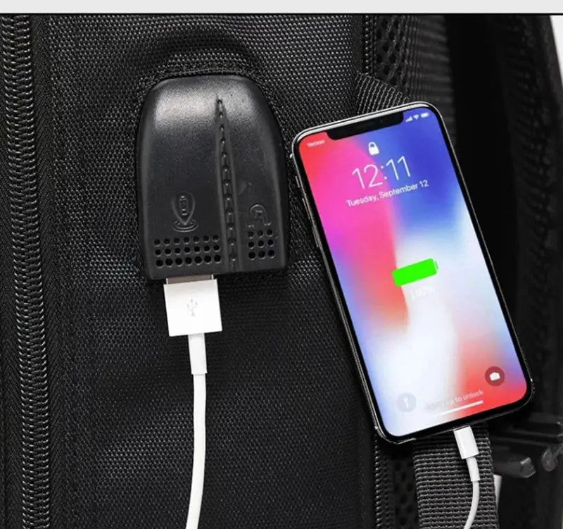 Black large travel backpack with built-in USB charging port and smartphone connected.