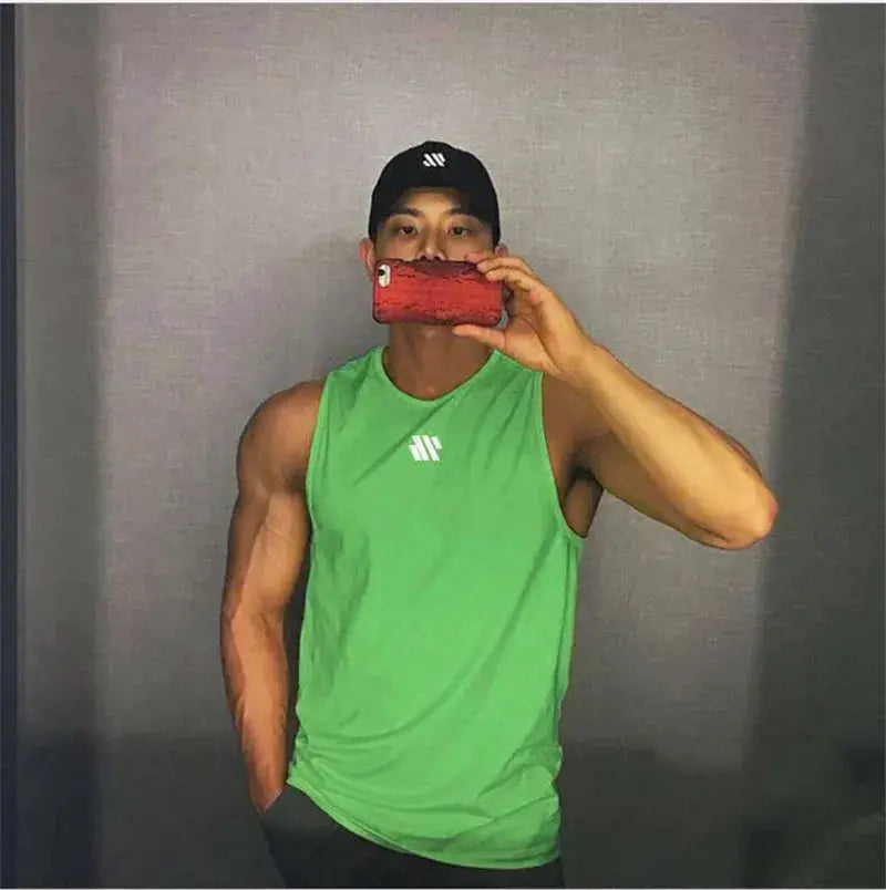 Men's lime green Simples Market logo sleeveless bodybuilding tank top; mirror selfie.