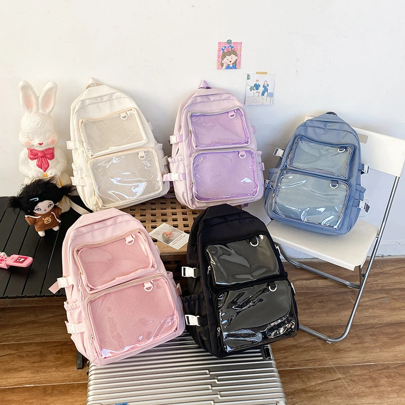 Japanese-style transparent ita bag backpacks; five in pink, beige, lavender, blue and black with clear mesh pockets.