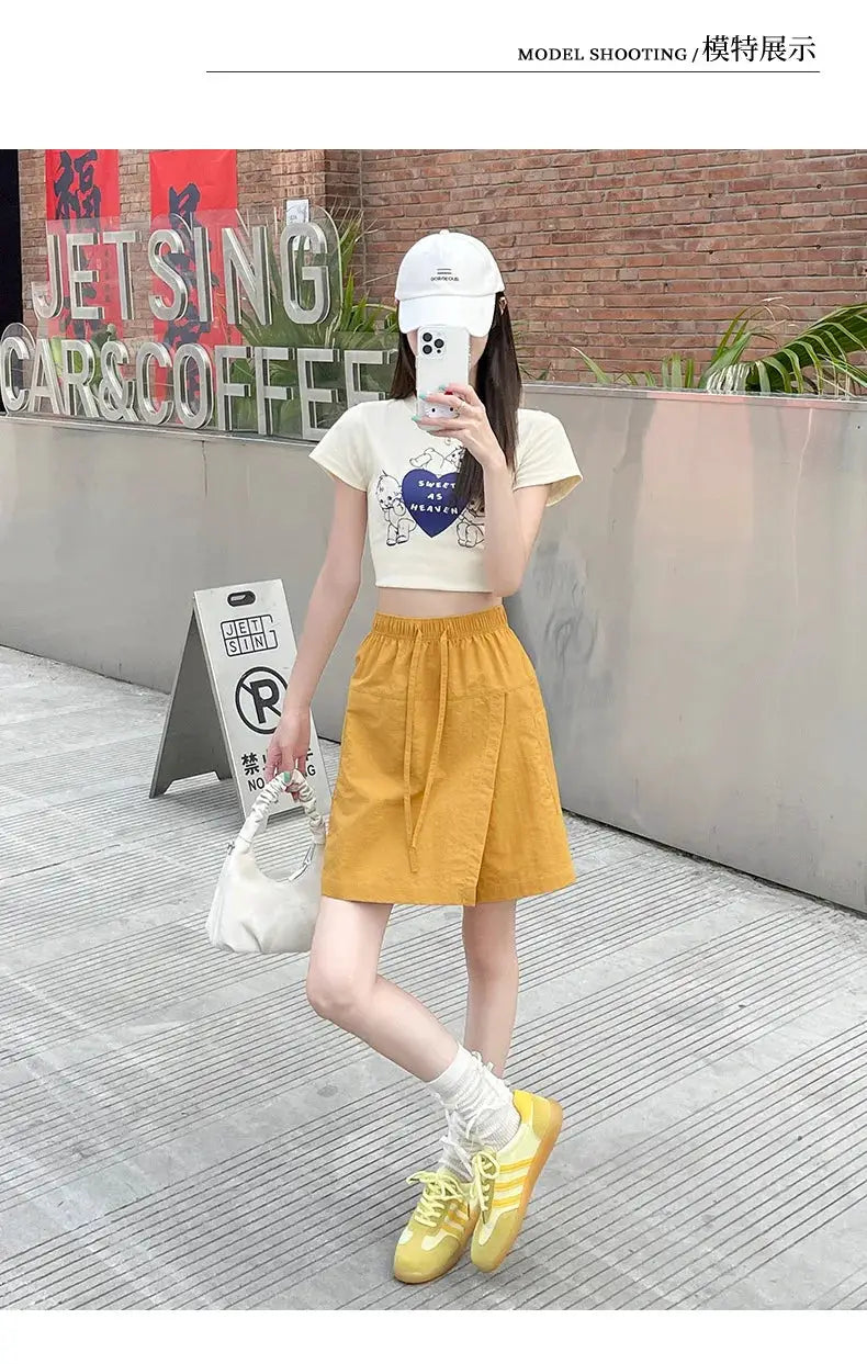 Mustard yellow A-line shorts skirt with drawstring waist and side pockets; lightweight casual mini skirt.