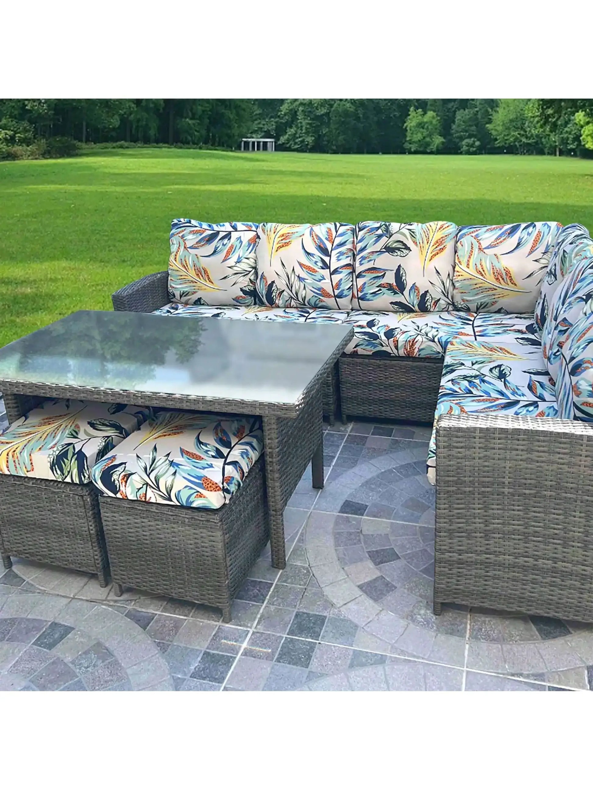 Simples Market outdoor tropical print sofa cushions on a wicker sectional with a glass-top coffee table