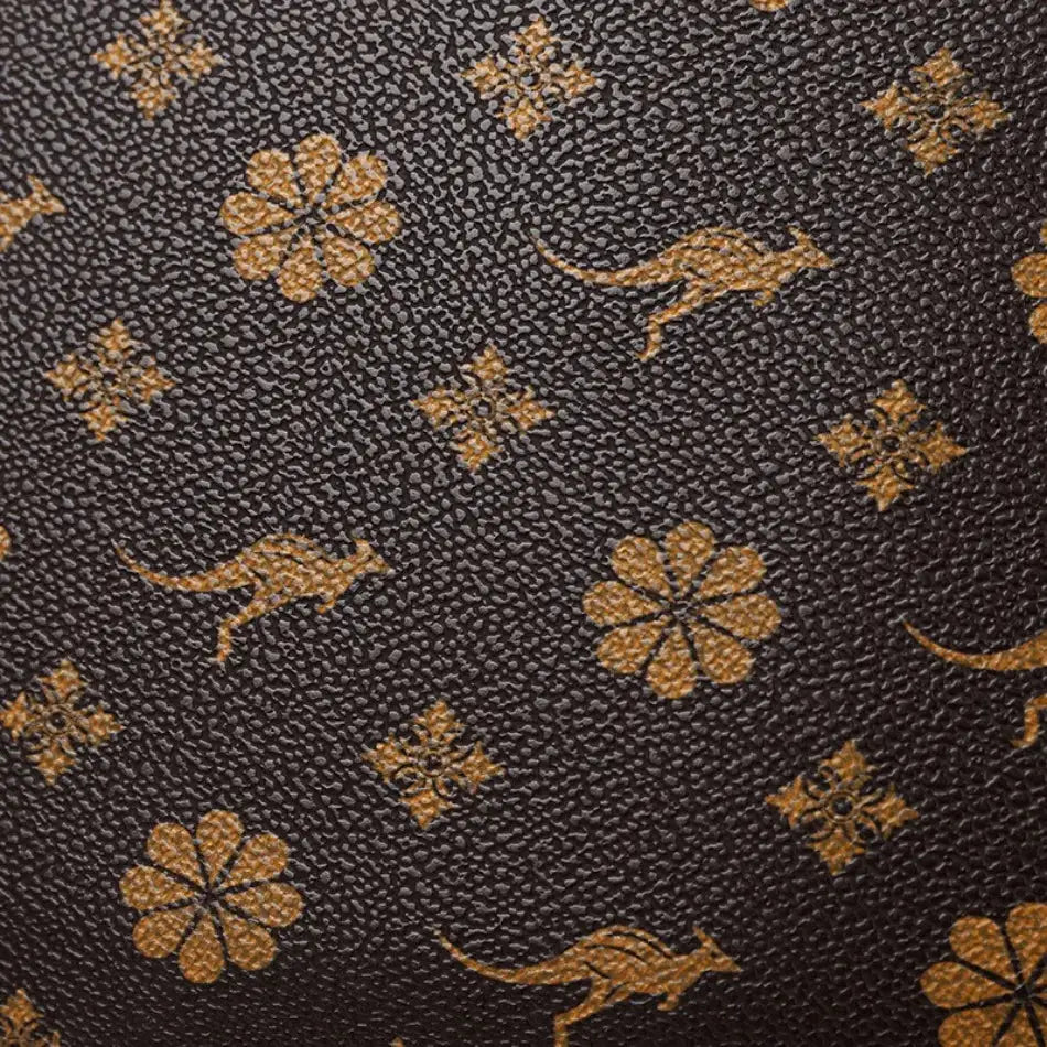 Leather backpack with dark brown textured surface and golden floral motifs