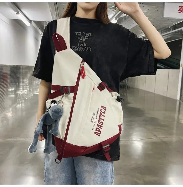 White nylon crossbody bag with red accents and multiple pockets, worn diagonally across the chest.