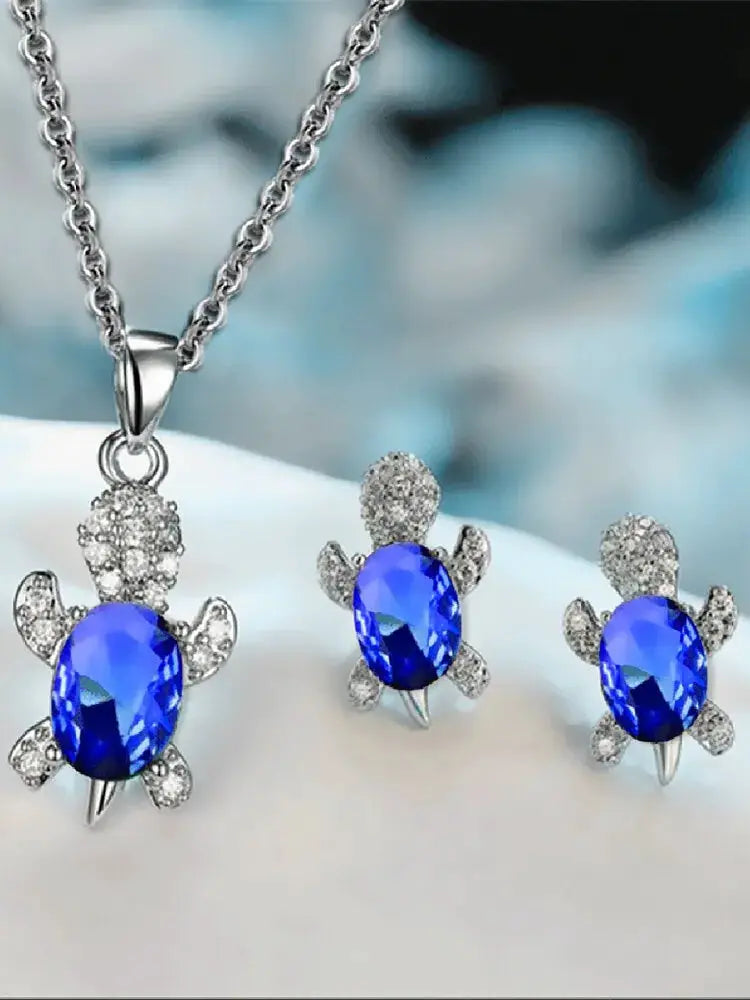 3pc turtle-shaped jewelry set: silver-plated necklace and matching earrings with blue oval stones and clear crystals