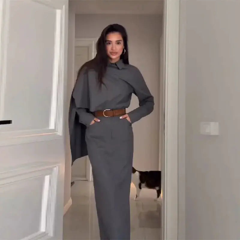 Vintage grey blazer suit set for women with polo-neck cape blouse and long straight skirt, brown belt.