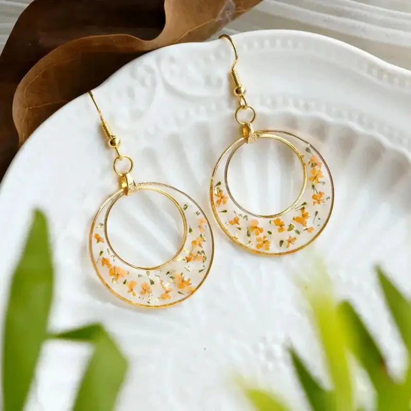 Unique design pressed flower earrings, Simples Market; gold-tone geometric hoops with orange flowers in epoxy resin