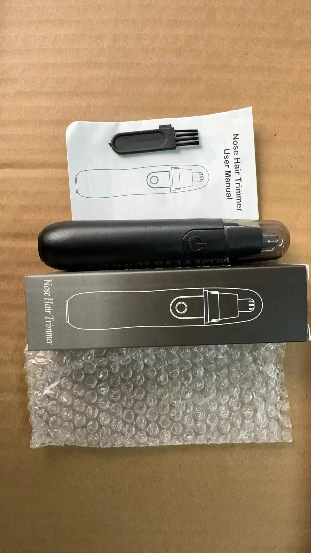 Nose hair trimmer kit by Simples Market, black handheld trimmer with cleaning brush, manual and box.