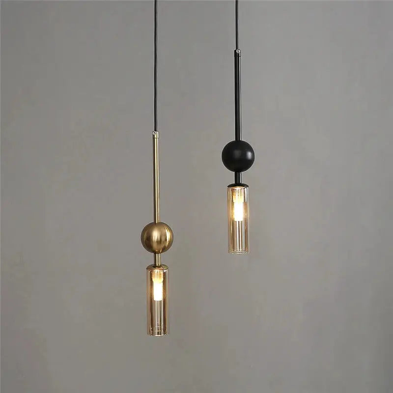 Two Nordic LED pendant lights in gold and black iron with glass cylinder shades