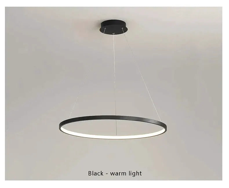 Round LED pendant light by Simples Market, black ring with warm white glow.