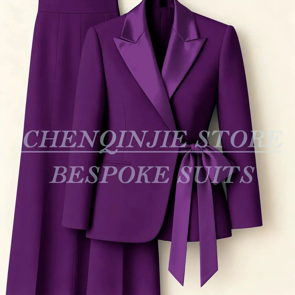 Purple women's 2-piece suit set with tailored blazer, satin peak lapels, waist-tie belt, and matching pants.