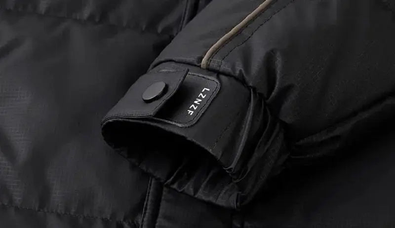 Men's black quilted down jacket cuff with snap strap detail, close-up.