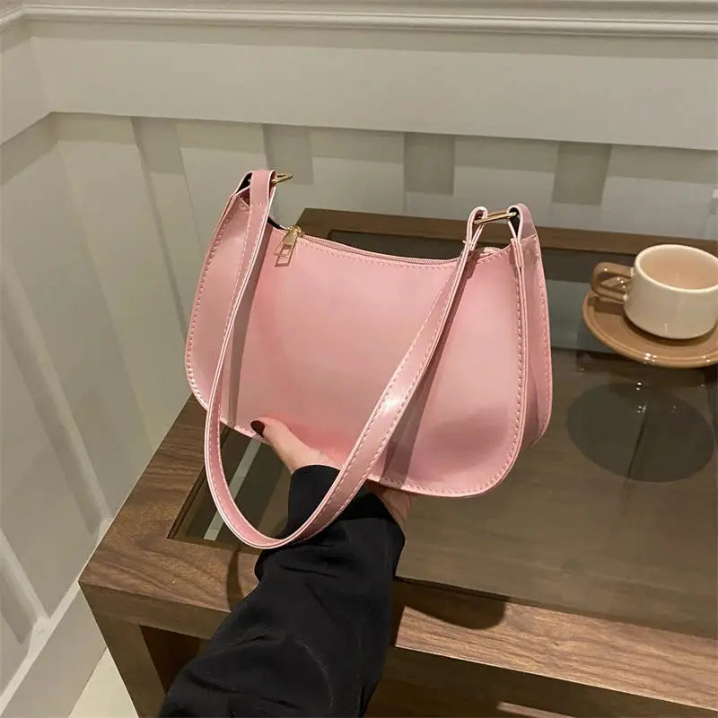 Shoulder bag in pink PU leather with gold zipper and long strap, retro casual women's handbag.