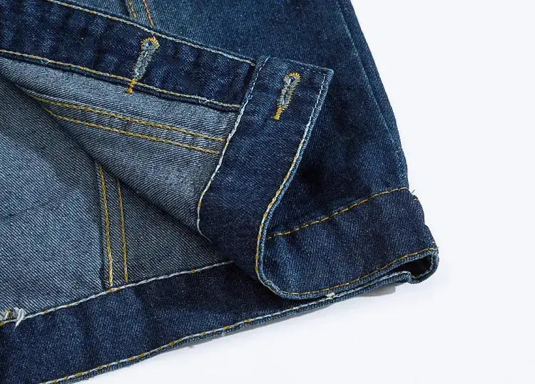 Denim jeans vest close-up in blue indigo with yellow contrast stitching, sleeveless men's jacket.