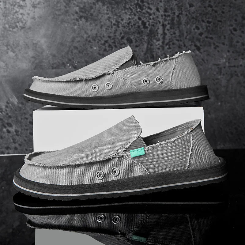 Pair of gray canvas loafers for men, slip-on low-top casual sneakers with frayed edges, breathable.