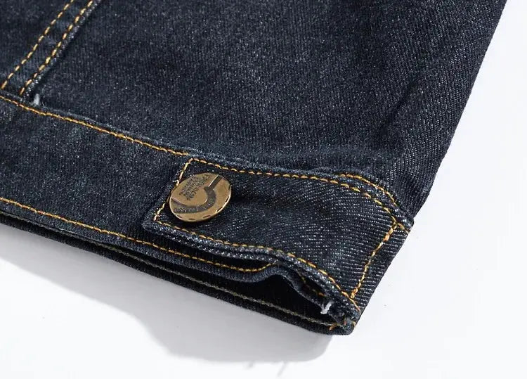 Denim jacket sleeve cuff with bronze button and orange topstitching