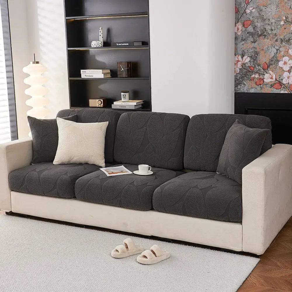 Three sofa seat cushions in dark gray jacquard fabric on a beige sofa in a modern living room