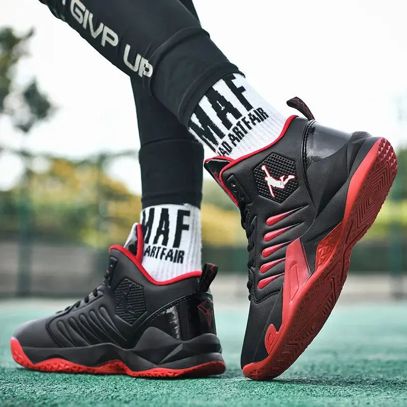 Pair of men's black and red sneakers with textured upper and red outsole, athletic trainer style