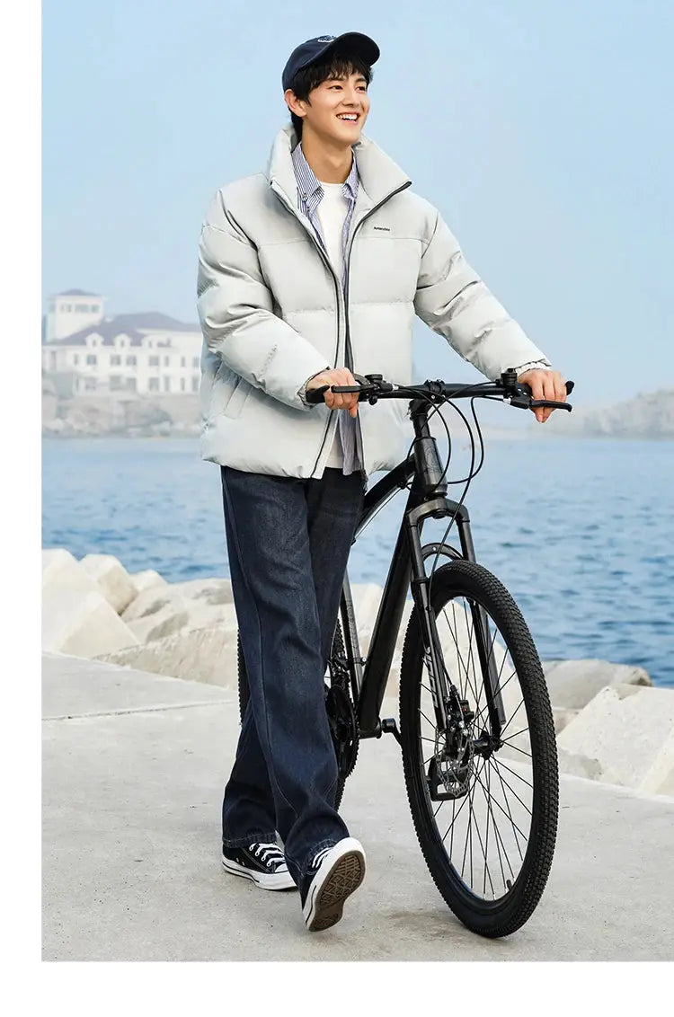 Semir down jacket; light gray puffer windproof, waterproof outerwear worn by man with bicycle by the sea