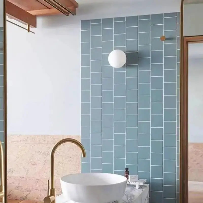 Milky white glass ball wall lamp, frosted round wall light mounted on blue tile wall