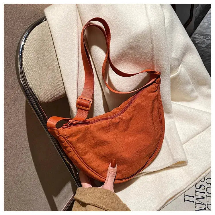 Casual nylon hobo crossbody bag for women in burnt orange with adjustable strap and large capacity.