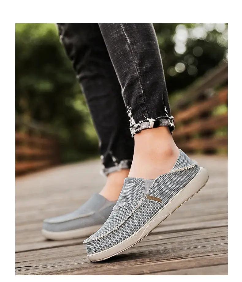 Men's canvas slip-on loafers by Simples Market; light gray casual shoes on a wooden boardwalk