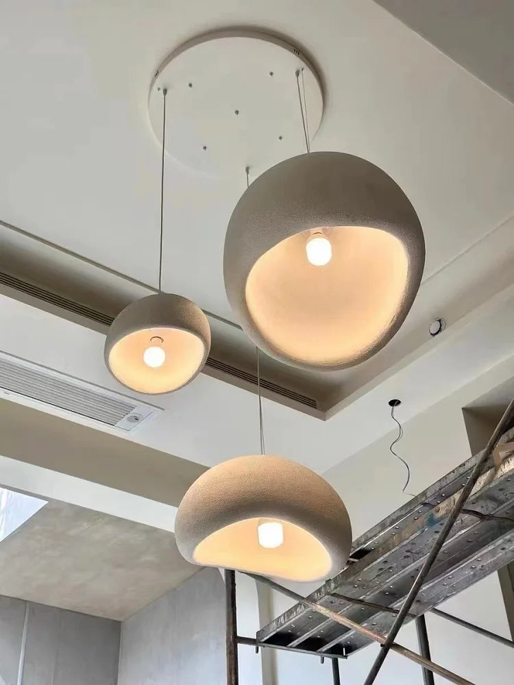 Nordic Wabi Sabi pendant lights by Simples Market; three gray textured dome LEDs with warm interior glow.
