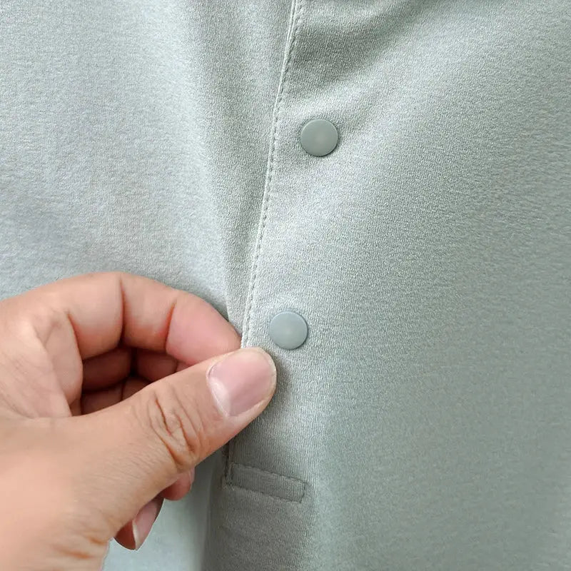Men's short-sleeve polo shirt in light sage with snap-button placket.