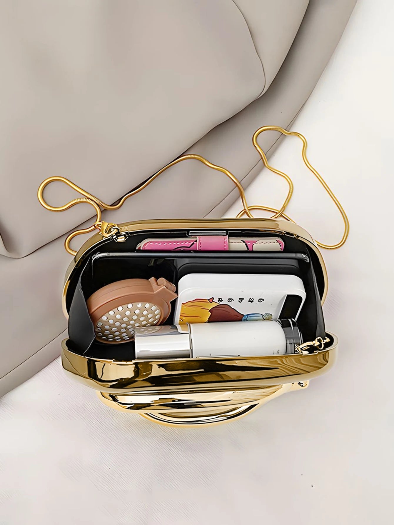 Simples Market acrylic box crossbody bag with gold chain, open to reveal interior items.