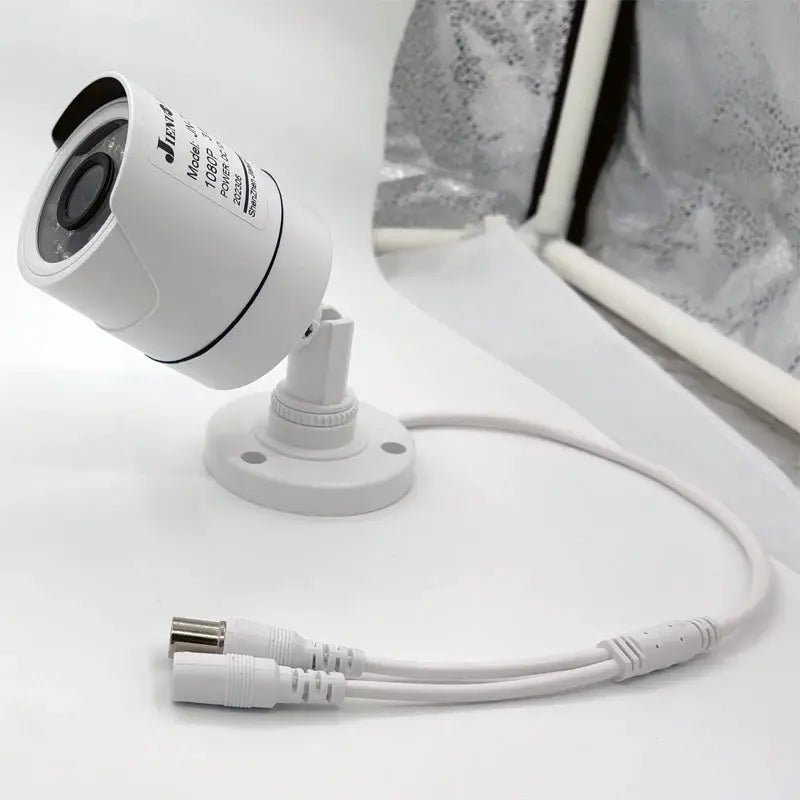 JIENUO white CCTV security camera on mounting bracket with attached BNC and power cables