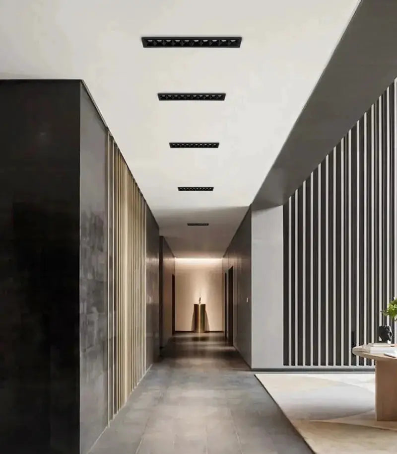 LED recessed rectangle downlights with black grille on the ceiling, five fixtures line a modern hallway