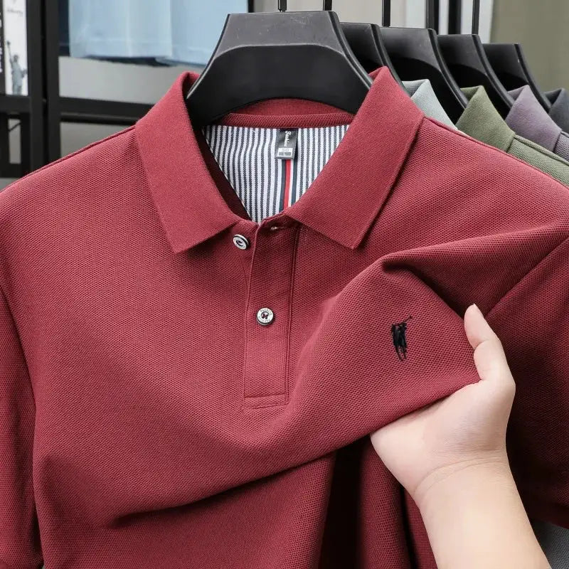 Maroon 100% cotton polo shirt with small black embroidery on chest, short sleeves, two-button placket.