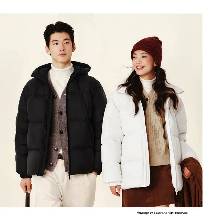 Semir down jackets for couple: black men's hooded puffer and white women's hooded puffer, solid colors.