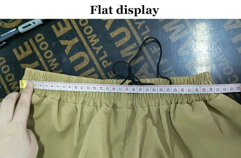 Men's beige cargo pants with elastic waistband and drawstring; loose, wide-leg workwear trousers