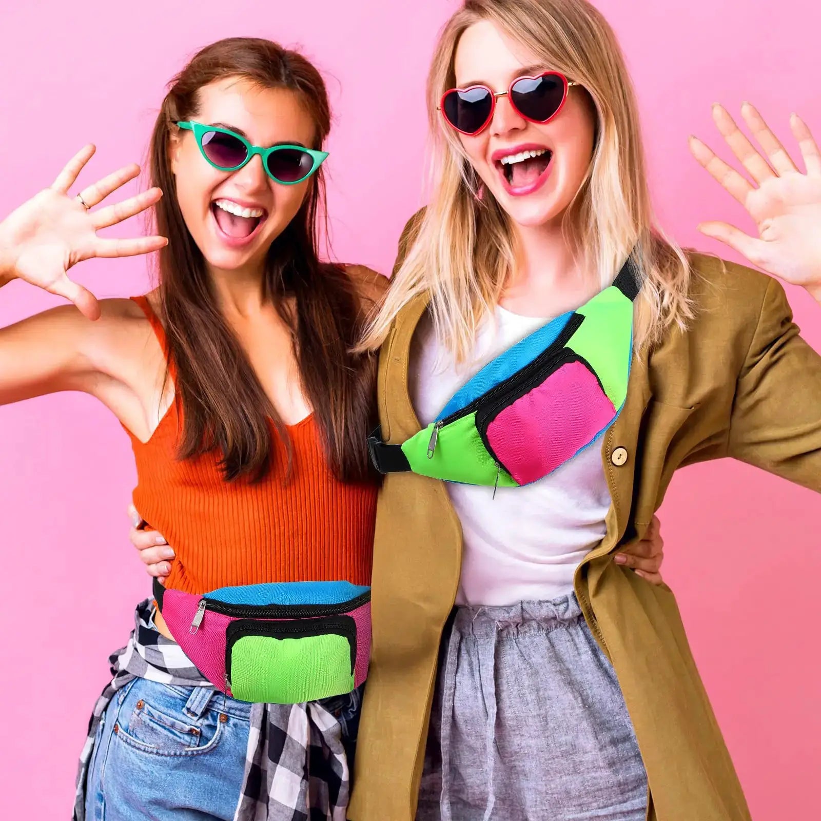Two neon color block fanny packs worn at the waist by smiling women against a pink background