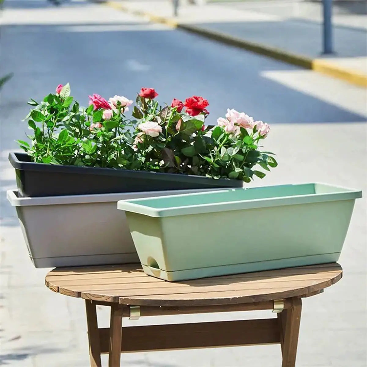Set of three rectangular plastic balcony planters with trays in green, gray and black