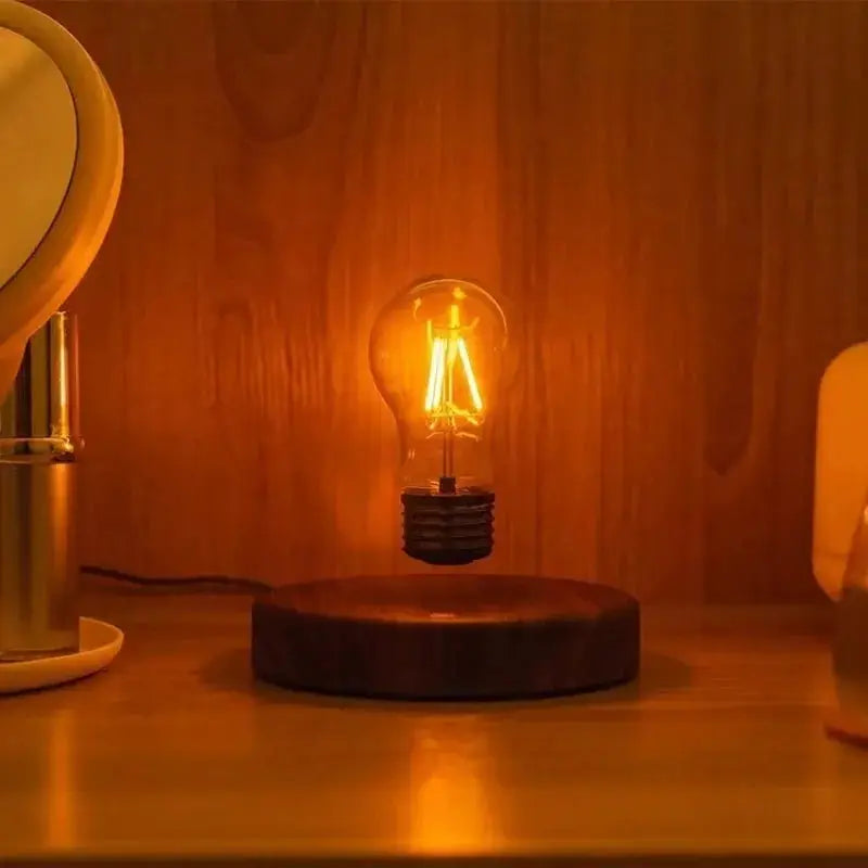 Magnetic levitation lamp with floating amber glass LED bulb on a wooden base by Simples Market