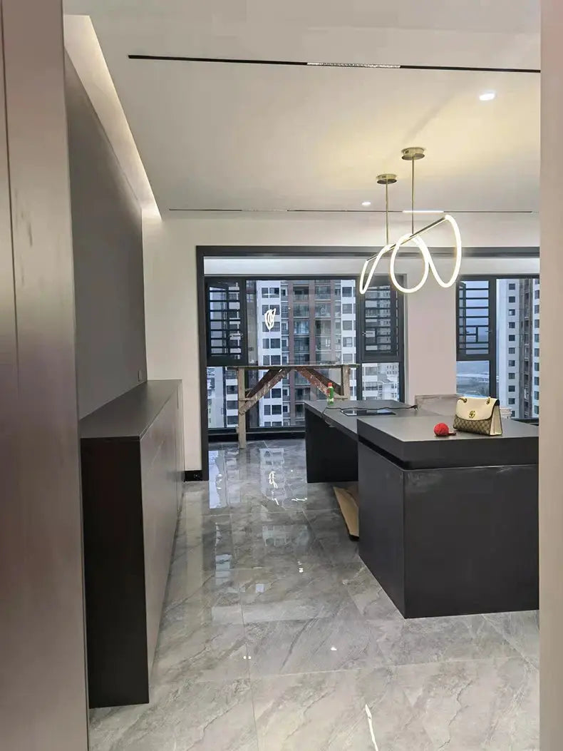 Pendant chandelier with double-loop white LED rings and gold mounts in a modern dining room.