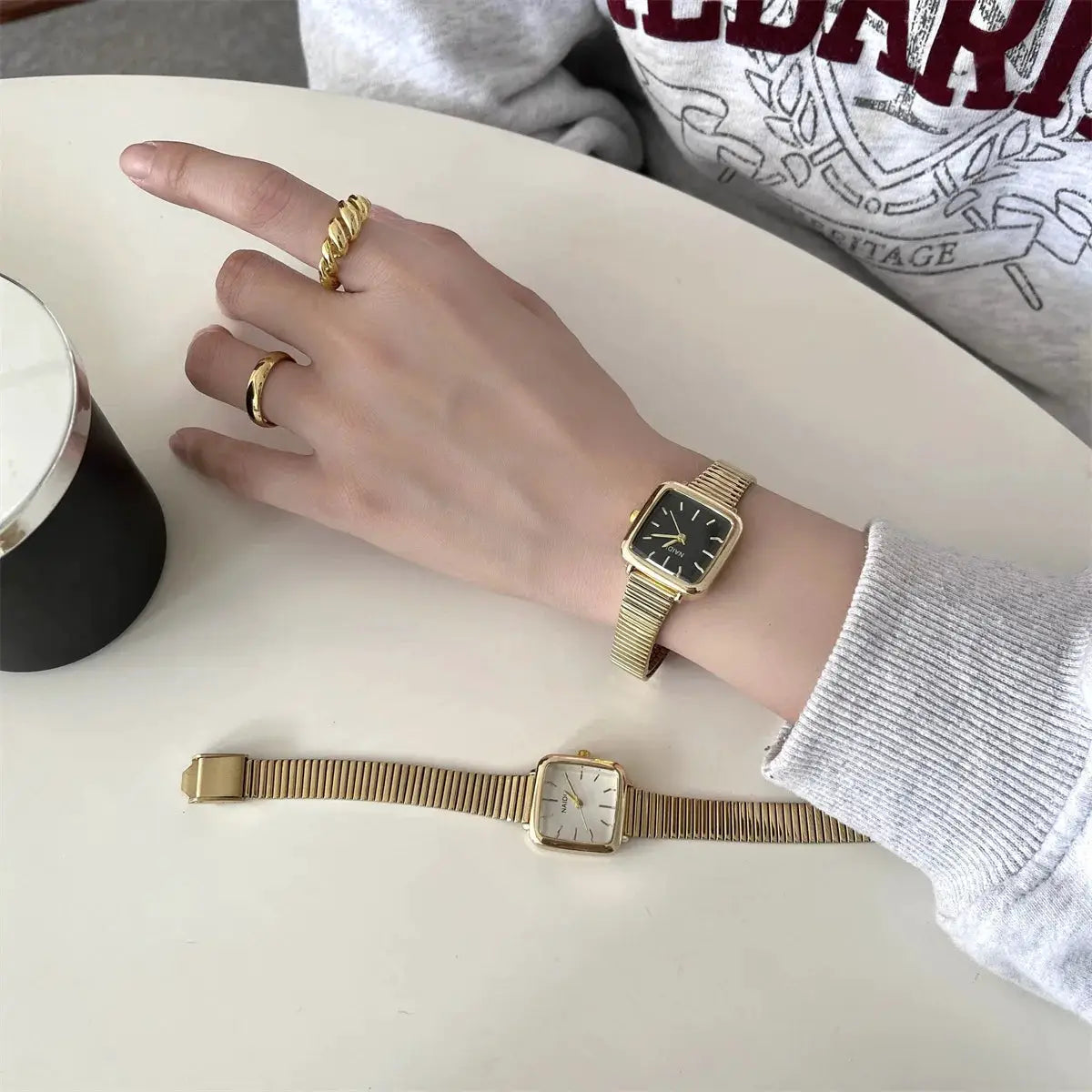 Women's gold quartz watches by Simples Market; two watches with stainless steel straps, black dial on wrist