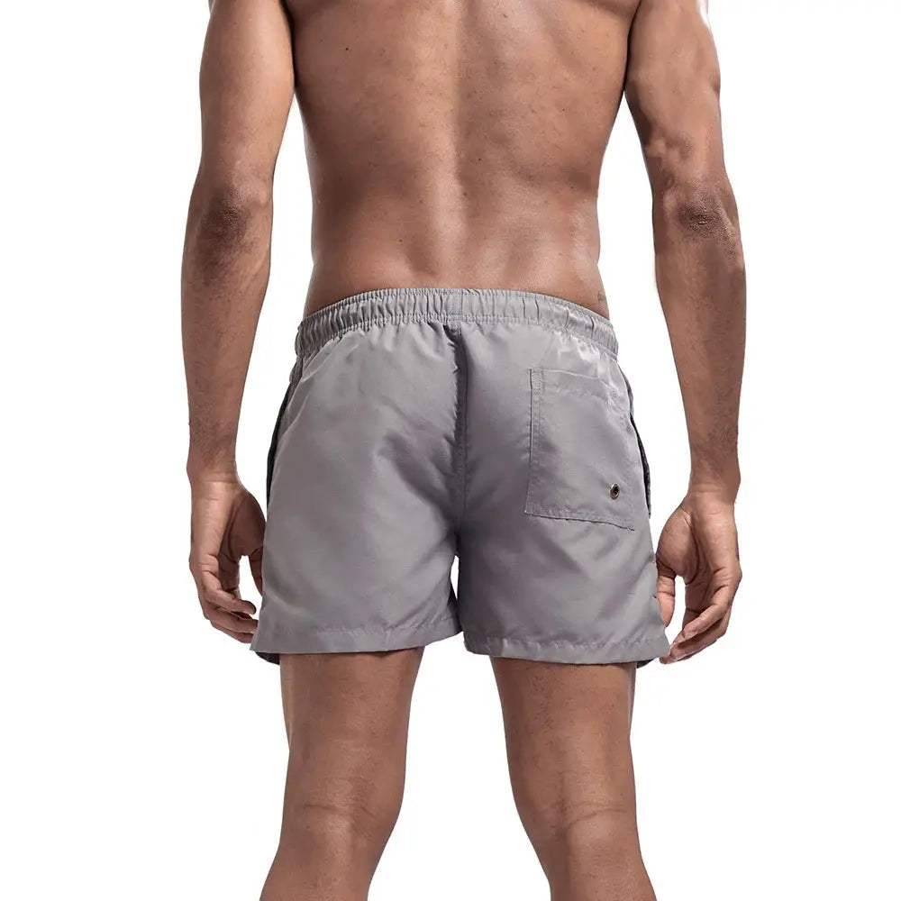 Men's gray quick-dry swim shorts with elastic waistband and back pocket.