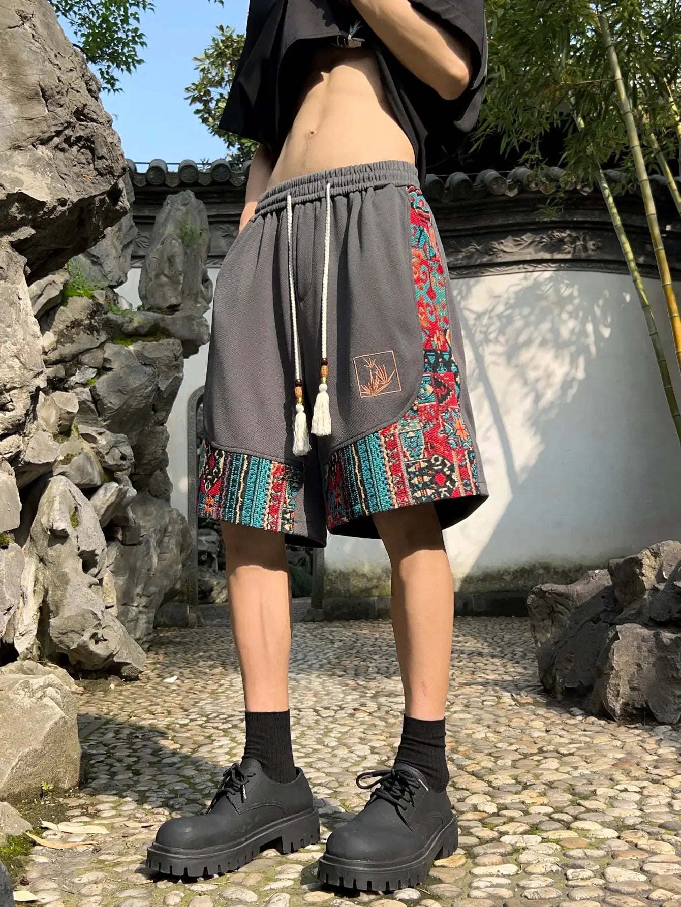 Men's ethnic embroidery shorts with pockets by Simples Market; gray fabric with colorful side panel and drawstring waist.