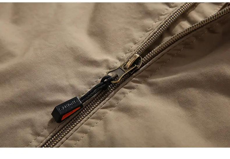 Tan men's outdoor waterproof jacket zipper close-up; beige shell fabric, windbreaker style