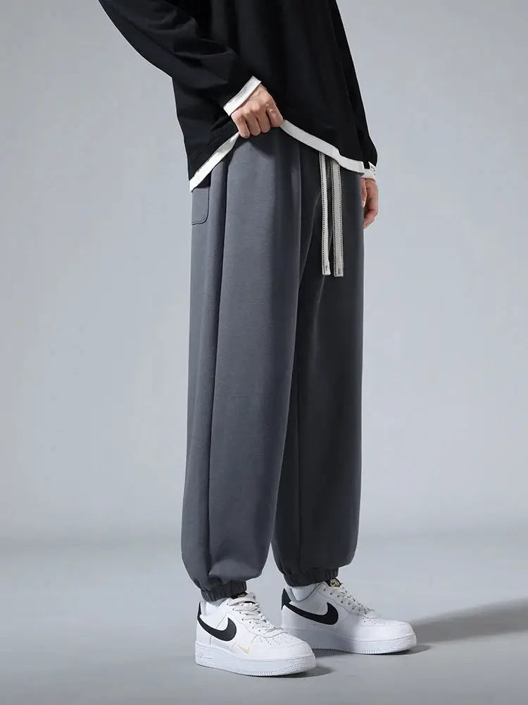 Men's grey cotton-polyester jogger sweatpants, baggy hip-hop style with drawstring, ankle cuffs.