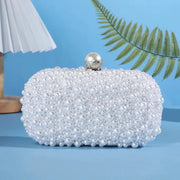 Handcrafted pearl evening bag by Simples Market; white pearl-beaded clutch with a pearl ball jeweled clasp