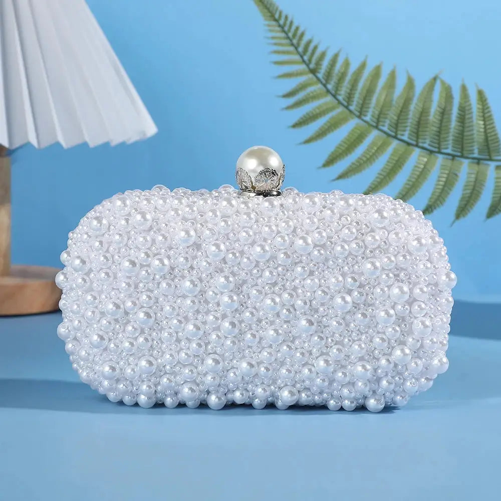 Handcrafted pearl evening bag by Simples Market; white pearl-beaded clutch with a pearl ball jeweled clasp
