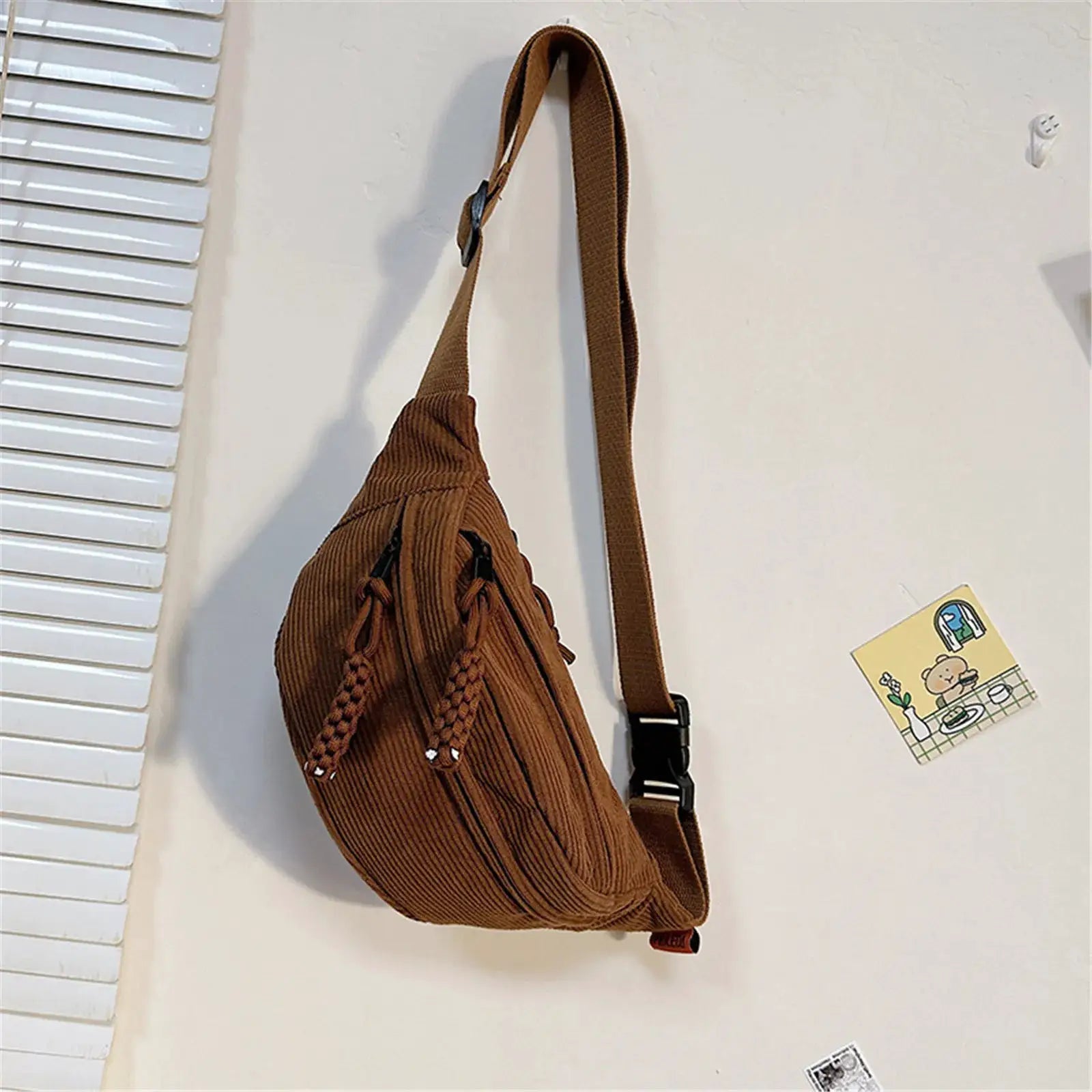 Brown corduroy belt bag with adjustable strap and tassel details