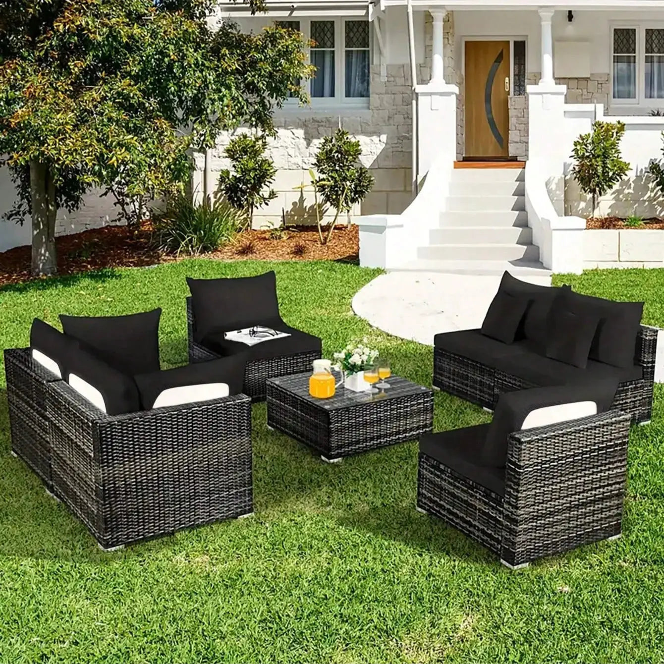 Outdoor black sofa cushions for wicker patio furniture on a green lawn