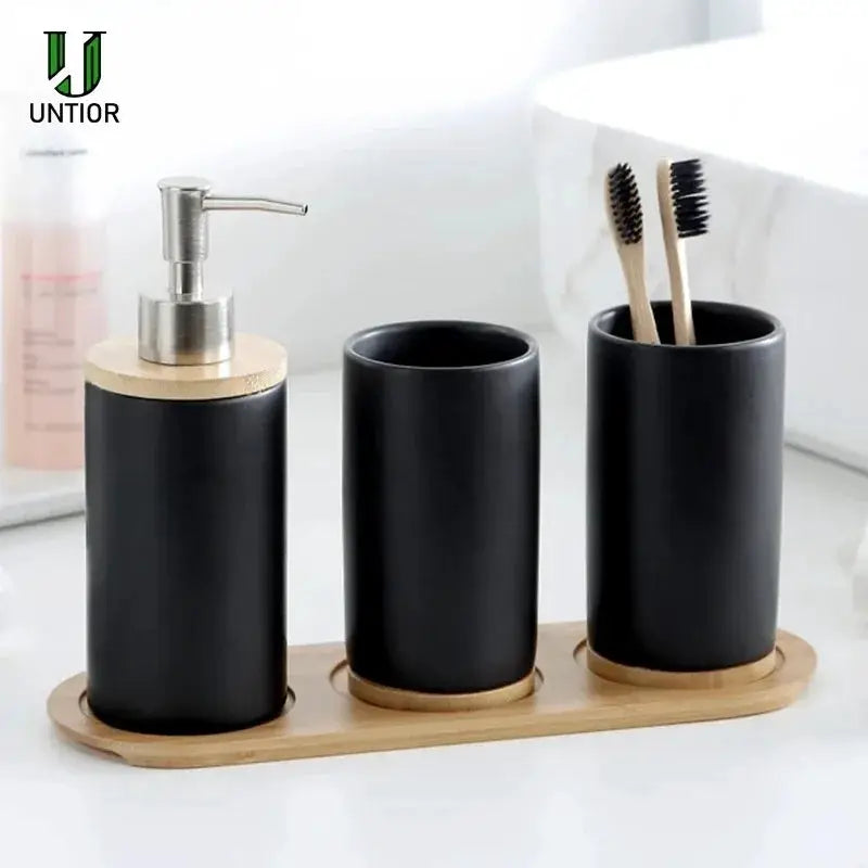 Untior ceramic bathroom set in black with bamboo base; three-piece soap dispenser, toothbrush holder, and tumbler.