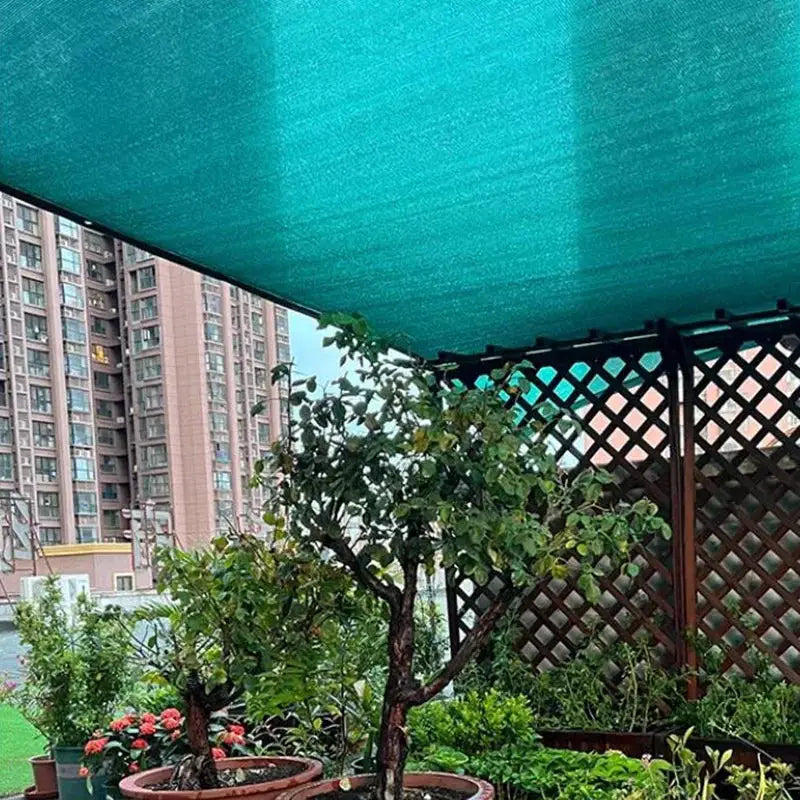 HDPE green sun shade net over potted plants in a garden patio