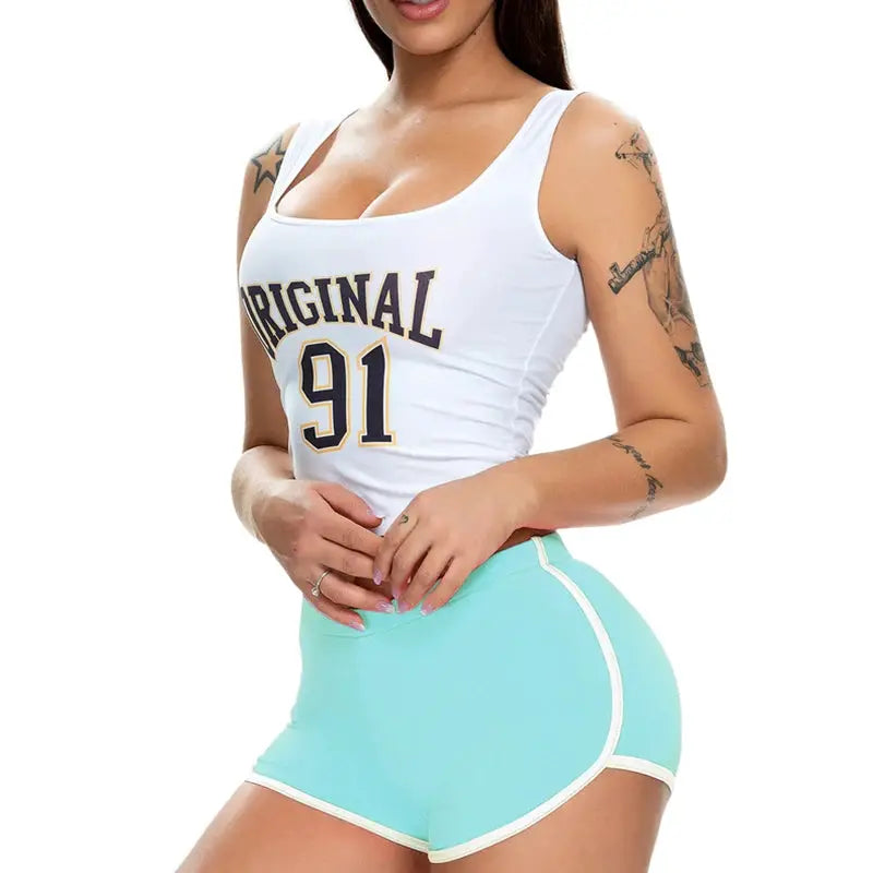 Women's two-piece athletic set: white sleeveless top with Original 91 print and turquoise shorts with white trim.